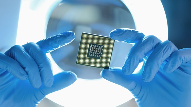 Worker holds chip made of specialty chemicals.